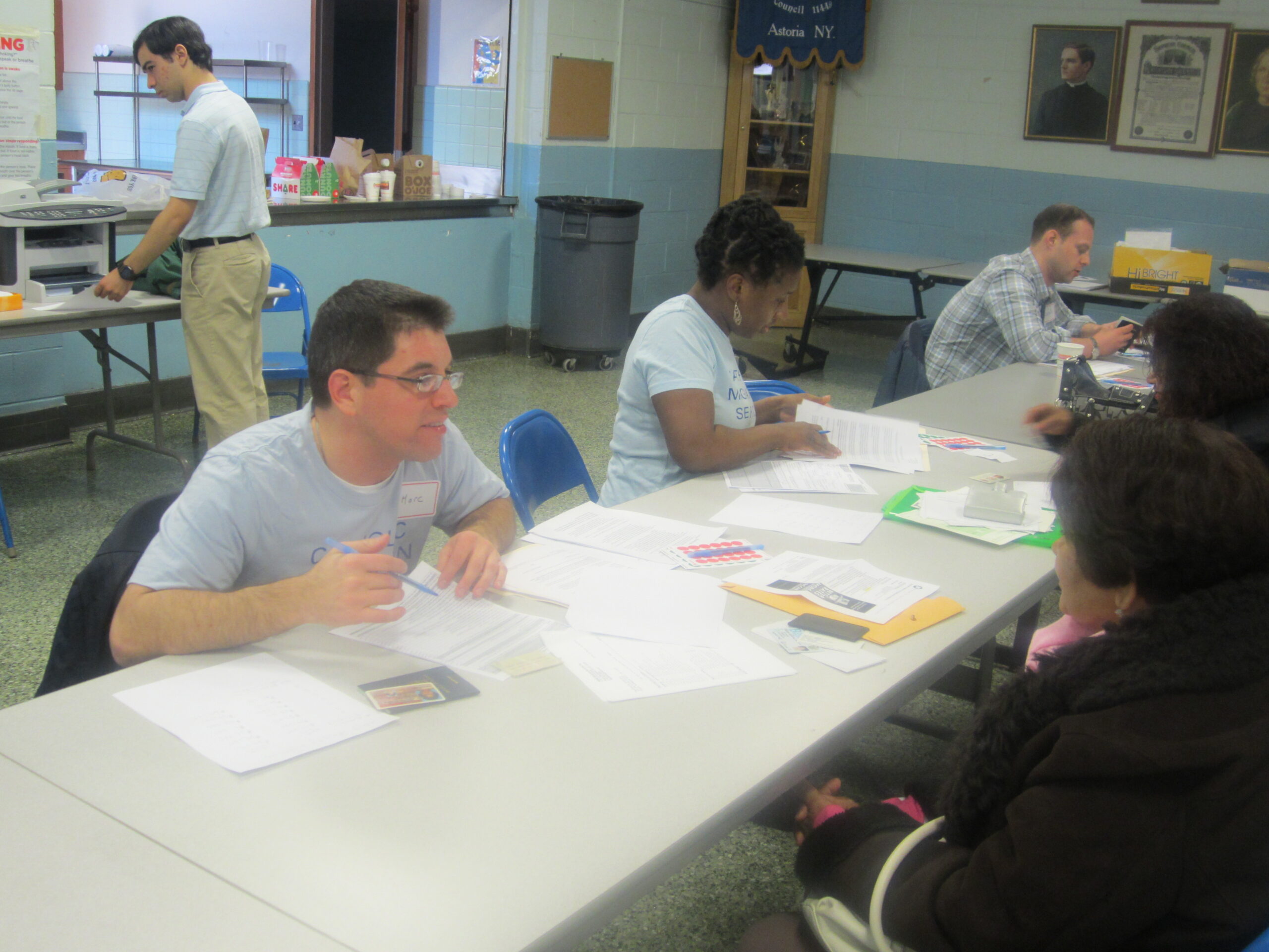 A man and a women discussing and at a table filing out applications