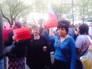 Two women holding up signs about rent