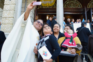 Priest taking a selfie with a family