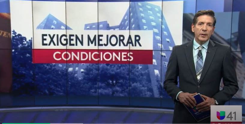 Screen shot of news broadcast. Male anchor in a suit holding cue cards introduces a news segment. The text on the screen reads "Exigen Mejorar Condiciones"