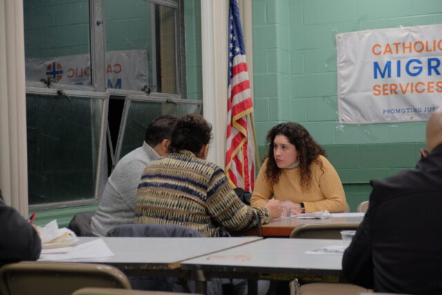 Three individuals sitting at a table in deep conversation.